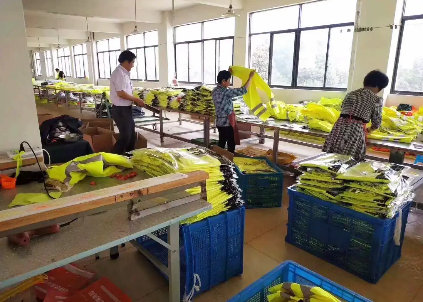 Finished high-visibility garments being checked and folded before bulk packing